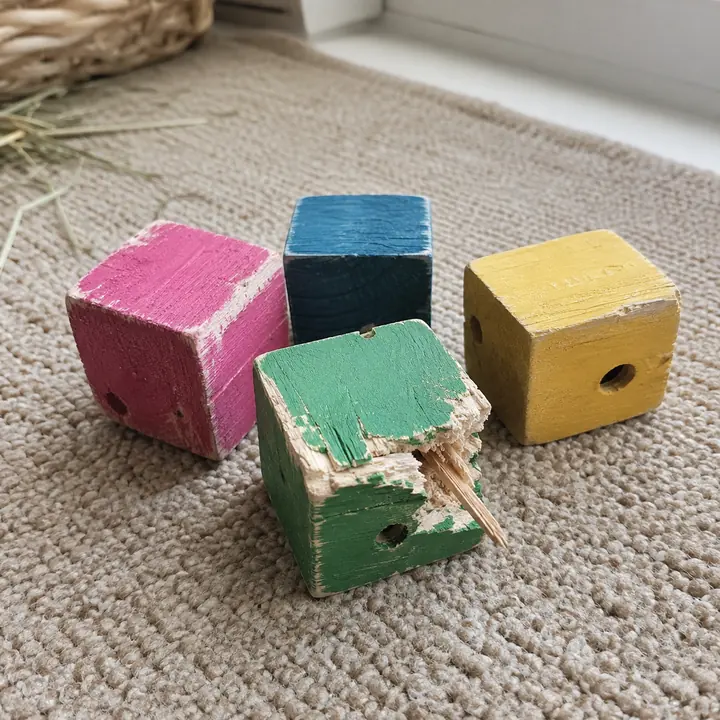 Painted wooden pet toy with chipped finish and a sharp splinter